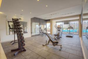 a gym with tread machines and a swimming pool at The House Boutique Suites in Amman
