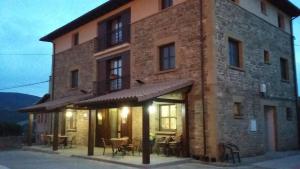 a building with tables and chairs in front of it at Hospedería Prepirineo in Undués-Pintano