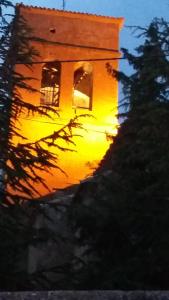 a clock tower with the sunset in the background at Hospedería Prepirineo in Undués-Pintano