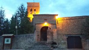 a building with a tower with a gate and stairs at Hospedería Prepirineo in Undués-Pintano