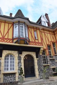 ein orangefarbenes und gelbes Haus mit einem Turm in der Unterkunft La Porte De Bretagne in Péronne