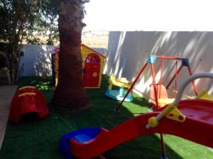 a childrens play area with two trees and a swing at Villa Galleria in Perivolia