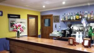 a bar with a vase of flowers on a counter at Hospedería Prepirineo in Undués-Pintano