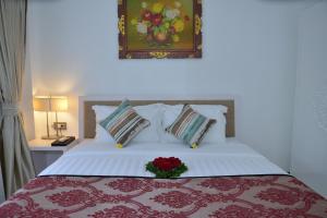 Un dormitorio con una cama con un arreglo floral. en Sofi Apartment at Jayakarta Residence, en Legian