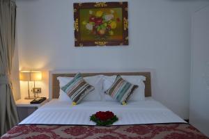 a bedroom with a bed with a flower arrangement on it at Sofi Apartment at Jayakarta Residence in Legian
