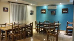 a dining room with blue walls and wooden tables and chairs at Hospedería Prepirineo in Undués-Pintano