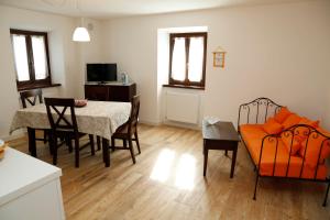 a living room with a dining room table and chairs at Cjase da Maestre in Raveo