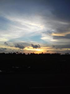 um céu nublado com um pôr-do-sol num campo em Mai Chenang Guesthouse em Pantai Cenang