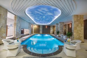 Swiss In Tabuk Hotel في تبوك: مسبح في فندق بسقف ثابت