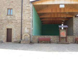 a building with a red bench and a green wall at Hospedería Prepirineo in Undués-Pintano