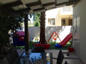 a patio with a play yard with a playground at Villa Galleria in Perivolia