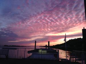 einen Sonnenuntergang über einem Wasserkörper mit einem Boot in der Unterkunft Nice n' Nordic 4 in Hamburg