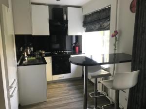 a kitchen with white cabinets and a table and chairs at Fine Apartment in Jelgava