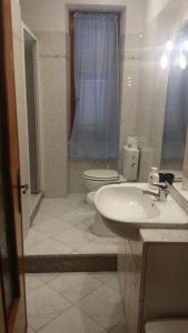 La salle de bains blanche est pourvue de toilettes et d'un lavabo. dans l'établissement Casa Nene, à La Spezia