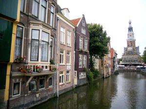 a view of a canal with buildings and a clock tower at Backyard in Alkmaar