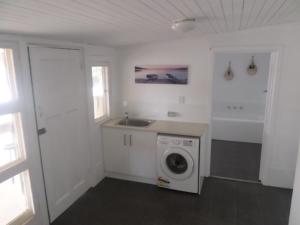 a kitchen with a washing machine and a sink at Dells Seaside Escape Moonta Bay in Port Moonta