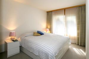 ロイカーバートにあるHaus Rothorn, Swiss Alpsの白いベッドルーム(ベッド1台、窓付)