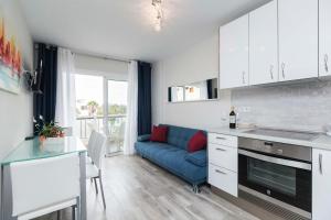 a kitchen and a living room with a blue couch at Apartamento El Dorado, Wi-Fi y aparcamiento gratuito in Playa de las Americas