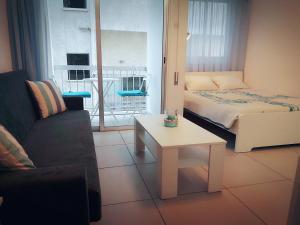 a room with a bed and a table and a couch at Billis Beach Apartment in Limassol