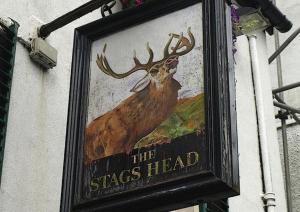 a sign for the stag head on the side of a building at Stags Head Hotel in Bowness-on-Windermere