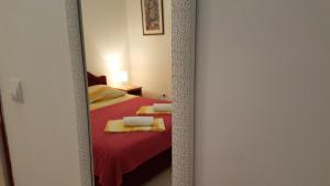 a mirror reflection of a bedroom with a red bed at Apartments TM in Bijela