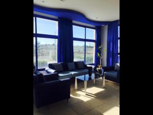 a living room with blue curtains and a couch at Auberge Oualidia Dream in Oualidia
