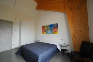 ein Schlafzimmer mit einem blauen Bett und einer Holzdecke in der Unterkunft Masseria La Meridiana in Altamura