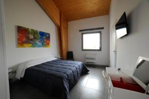 Schlafzimmer mit einem Bett, einem Schreibtisch und einem Fenster in der Unterkunft Masseria La Meridiana in Altamura