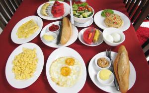 a red table with plates of food on it at Blossoming Romduol Boutique in Siem Reap