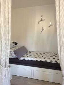 ブレーマーハーフェンにあるFerienwohnung Möweのベッド1台(壁に鳥が飾られた)
