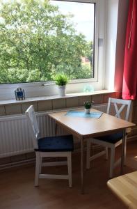 - une table et des chaises dans une chambre avec fenêtre dans l'établissement Ferienwohnung "Krabbe", à Bremerhaven
