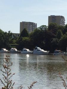 einer Gruppe von Booten, die in einem Fluss mit hohen Gebäuden angedockt sind in der Unterkunft Ferienwohnung Möwe in Bremerhaven