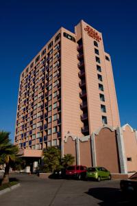 un gran edificio con coches estacionados frente a él en Hotel Villa Marina, en Ensenada