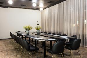 una sala conferenze con un lungo tavolo e sedie nere di Leonardo Boutique Jerusalem a Gerusalemme Altre 61 foto