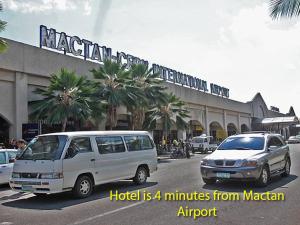 een wit busje geparkeerd voor een gebouw bij Mactan District Budgetel - Lapu Lapu Cebu in Mactan