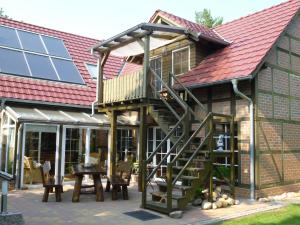 ein Haus mit einer Terrasse mit einer Treppe darauf in der Unterkunft Ferienwohnung Kluge in Markische Heide