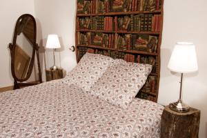 - une chambre avec un lit et un mur de livres dans l'établissement Chezlesgoyp, à Cosges