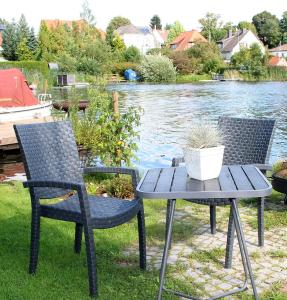 two chairs and a table next to a lake at Apartment am Stadtsee in Mölln