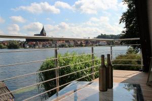 a bottle of wine sitting on a table next to a river at Apartment am Stadtsee in Mölln