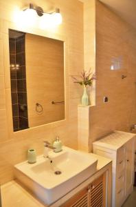 Apartament KARINA في تيلسز: حمام مع حوض أبيض ومرآة