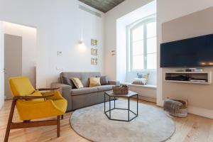 uma sala de estar com um sofá e uma cadeira em FLH Alecrim Modern Flat em Lisboa