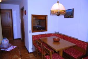 a living room with a table and a red couch at Campiglio Bilocale Monte Spinale in Madonna di Campiglio