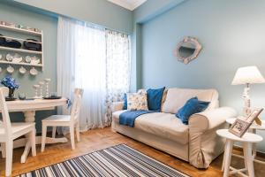 アテネにあるCharming Acropolis Metro Station apartment, clean and cozyの青い壁のリビングルーム(白いソファ付)