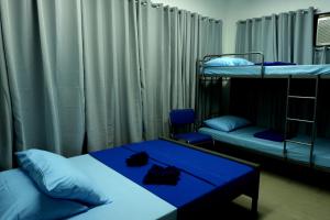麥克坦的住宿－麥克坦宿務機場經濟型酒店，客房设有两张双层床和一张蓝色的桌子。