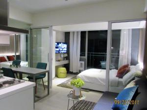 a bedroom with a bed and a table and a kitchen at Azure Urban Beach Resort Manila by Radlett in Manila
