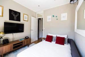um quarto com uma cama grande e uma televisão de ecrã plano em Ola Lisbon - Principe Real III em Lisboa