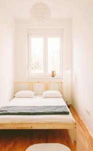 a bed in a white room with a window at Apartment Savska in Zagreb