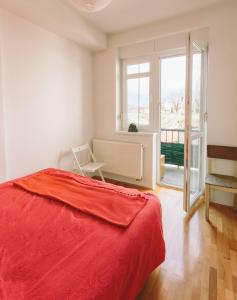 a bedroom with a red bed and a window at Apartment Savska in Zagreb