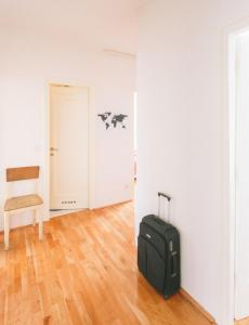 an empty room with a suitcase and a chair at Apartment Savska in Zagreb