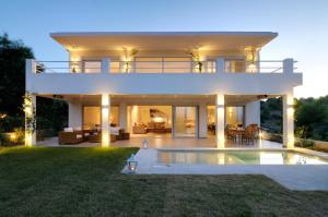 a villa with a swimming pool at night at Vineyard Estate in Porto Heli